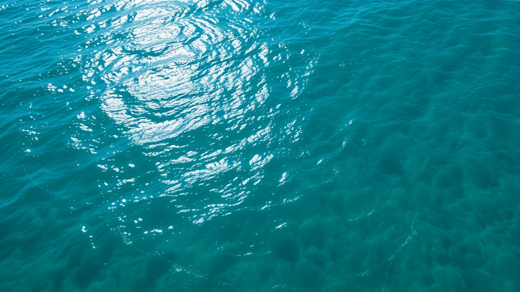 Aerial view of sunlit ocean surface with phytoplankton-rich waters, vibrant blue-green coloration, natural light patterns, productive aquatic ecosystem without visible text or graphics